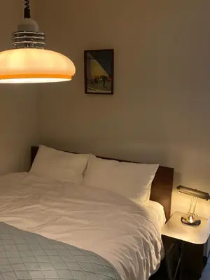 a bedroom with a white bed and a lamp at \u4e2d\u91ce\u99c5\u5357inn Nakano Station South Inn in Tokyo