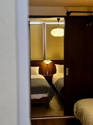 a bedroom with two beds and a lamp and a mirror at \u4e2d\u91ce\u99c5\u5357inn Nakano Station South Inn in Tokyo