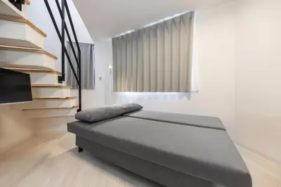 a bedroom with a bed in a room with a window at SJ Stay in Tokyo