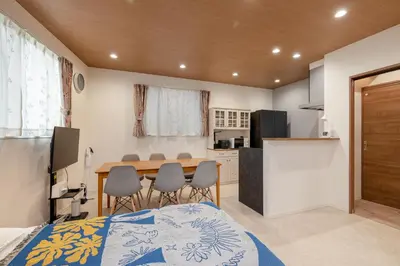 a room with a table and chairs and a kitchen at \u65b0\u5bbf\u307e\u306715\u5206 \u5f25\u751f\u753a\u306e\u6238\u5efa\u3066 in Tokyo
