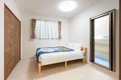 a small bedroom with a bed and a window at \u65b0\u5bbf\u307e\u306715\u5206 \u5f25\u751f\u753a\u306e\u6238\u5efa\u3066 in Tokyo
