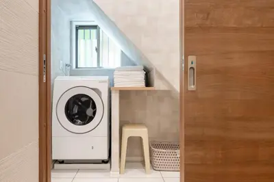 a bathroom with a washing machine and a stool at \u65b0\u5bbf\u307e\u306715\u5206 \u5f25\u751f\u753a\u306e\u6238\u5efa\u3066 in Tokyo