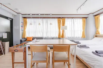 a room with two beds and a table and chairs at Private Floors 2F and 3 to 5F for up to 18 Guests 8 min walk from JR Hamamatsucho HOTEL Musashi Tokyo Shiba in Tokyo
