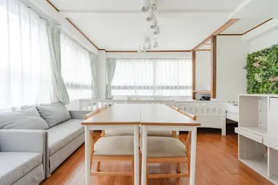 a living room with a table and a couch at Private Floors 2F and 3 to 5F for up to 18 Guests 8 min walk from JR Hamamatsucho HOTEL Musashi Tokyo Shiba in Tokyo