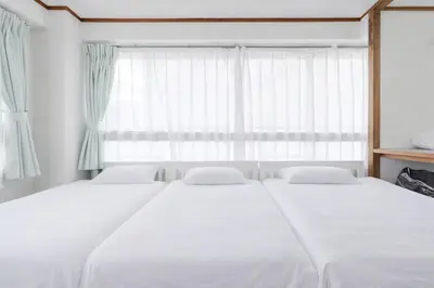 two beds in a bedroom with a large window at Private Floors 2F and 3 to 5F for up to 18 Guests 8 min walk from JR Hamamatsucho HOTEL Musashi Tokyo Shiba in Tokyo