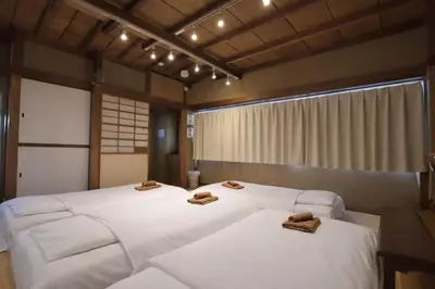 a bedroom with two beds with slippers on them at Private Floors 2F and 3 to 5F for up to 18 Guests 8 min walk from JR Hamamatsucho HOTEL Musashi Tokyo Shiba in Tokyo