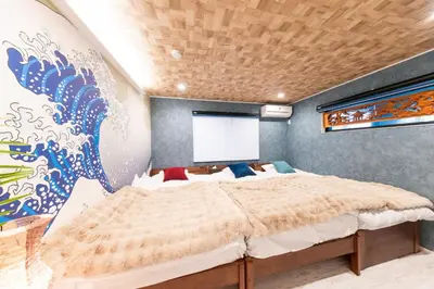 a bedroom with a large bed with a painting on the wall at 3-minute walk from Nishi-Shinjuku Station 100square meters Entire Private House 4LDK in Tokyo