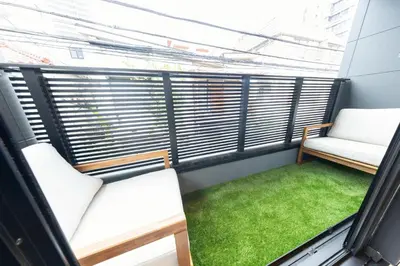 a balcony with two chairs and a green grass at 3-minute walk from Nishi-Shinjuku Station 100square meters Entire Private House 4LDK in Tokyo