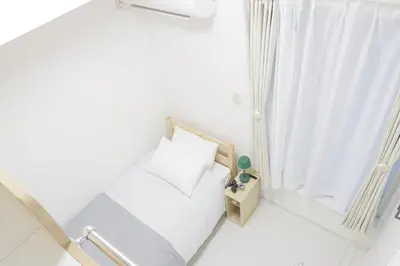 a small white room with a bed and a window at Dori Dori House Sumida in Tokyo