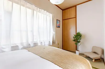 a bedroom with a bed and a chair and a window at ntb\u5800\u52072\u4e01\u76eeESTA 2 in Tokyo