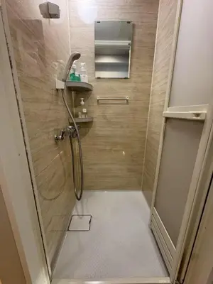 a bathroom with a shower with a glass door at Minshuku 203 under the clear sky 8-minute walk from Kinshicho Station direct line to Narita Airport 50-minute walk from Disneyland and 1-minute walk from the mall in Tokyo