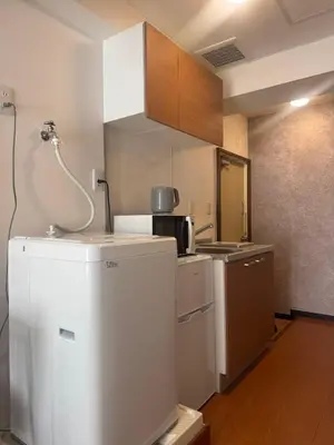 a kitchen with a refrigerator and a microwave at Clear Sky Guesthouse 205 Direct to Narita Airport, 8-minute walk from Kinshicho Station, within walking distance of Asakusa and Clear Sky Tower, 50 minutes to Disneyland, 1 minute to the mall in Tokyo