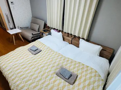 a bedroom with a bed with two towels on it at Clear Sky Guesthouse 205 Direct to Narita Airport, 8-minute walk from Kinshicho Station, within walking distance of Asakusa and Clear Sky Tower, 50 minutes to Disneyland, 1 minute to the mall in Tokyo
