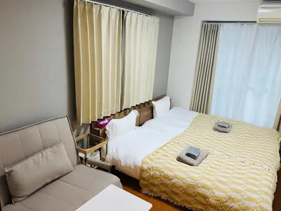 a hotel room with a bed and a chair at Clear Sky Guesthouse 205 Direct to Narita Airport, 8-minute walk from Kinshicho Station, within walking distance of Asakusa and Clear Sky Tower, 50 minutes to Disneyland, 1 minute to the mall in Tokyo