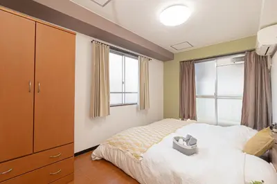 a bedroom with a bed and a window at Clear Sky Guesthouse 305 Direct to Narita Airport, 8-minute walk from Kinshicho Station, within walking distance of Asakusa and Clear Sky Tower, 50 minutes to Disneyland, 1 minute to the mall in Tokyo