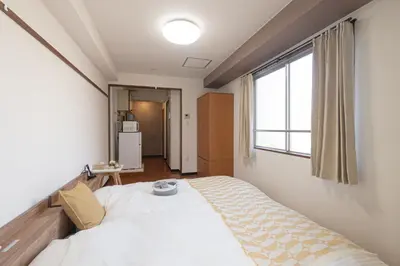a bedroom with a large bed with a window at Clear Sky Guesthouse 305 Direct to Narita Airport, 8-minute walk from Kinshicho Station, within walking distance of Asakusa and Clear Sky Tower, 50 minutes to Disneyland, 1 minute to the mall in Tokyo