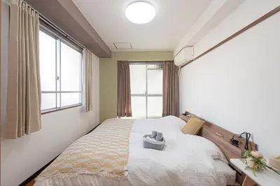 a bedroom with a large bed and a window at Clear Sky Guesthouse 305 Direct to Narita Airport, 8-minute walk from Kinshicho Station, within walking distance of Asakusa and Clear Sky Tower, 50 minutes to Disneyland, 1 minute to the mall in Tokyo