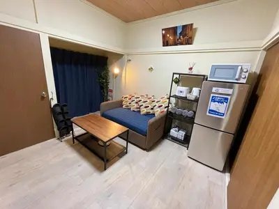 a living room with a couch and a refrigerator at NEW OPEN Available for 10 people 1 line to airport in Tokyo