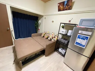 a small room with a bed and a refrigerator at NEW OPEN Available for 10 people 1 line to airport in Tokyo