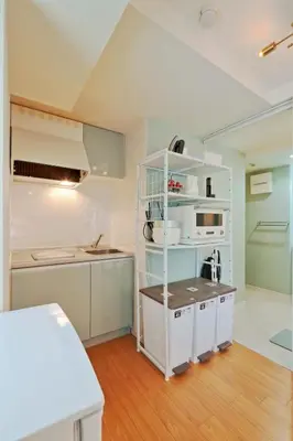 a kitchen with white cabinets and a white shelf at v close to Noagata 15 min to Shinjuku station in Tokyo