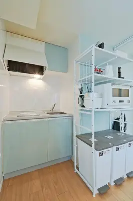 a kitchen with blue cabinets and a white shelf at v close to Noagata 15 min to Shinjuku station in Tokyo