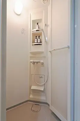 a small bathroom with a white refrigerator and a shelf at v close to Noagata 15 min to Shinjuku station in Tokyo