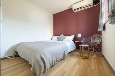 a bedroom with a large bed and a chair at \u65e5\u66ae\u91ccMori House A in Tokyo