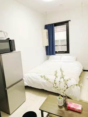 a bedroom with a bed and a table with a coffee table at \u30b5\u30af\u30e9\u30b7\u30e3\u30c9\u30a6\u9280\u5ea7502 in Tokyo