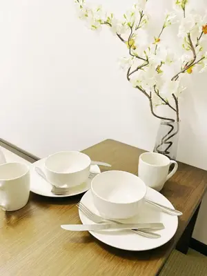 a table with plates and cups and a vase with flowers at \u30b5\u30af\u30e9\u30b7\u30e3\u30c9\u30a6\u9280\u5ea7502 in Tokyo