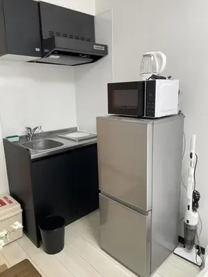a kitchen with a microwave on top of a refrigerator at \u30b5\u30af\u30e9\u30b7\u30e3\u30c9\u30a6\u9280\u5ea7502 in Tokyo