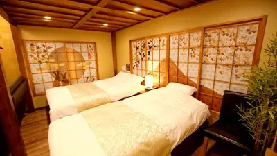 a bedroom with two beds and a potted plant at \u304a\u5bbf\u5be7\u3005OyadoNene\u677f\u6a4b \u6c60\u888b3\u5206\u65b0\u5bbf9\u5206 in Tokyo
