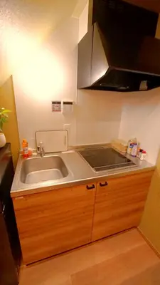 a small kitchen with a sink and a stove at \u304a\u5bbf\u5be7\u3005OyadoNene\u677f\u6a4b \u6c60\u888b3\u5206\u65b0\u5bbf9\u5206 in Tokyo