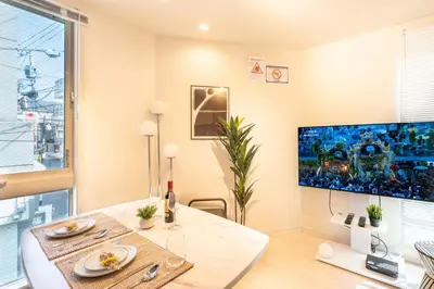 a living room with a table and a large tv at \u5922\u306e\u5bbf \u6771\u4e2d\u91ce 134t in Tokyo