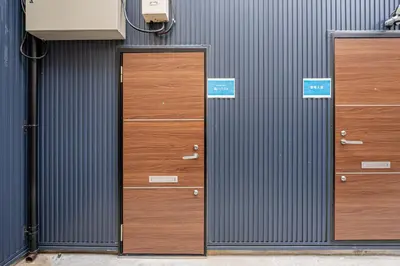 three wooden doors on the side of a building at \u65e5\u66ae\u91ccMori House B in Tokyo