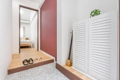 a hallway with a door and two pairs of shoes at \u65e5\u66ae\u91ccMori House B in Tokyo