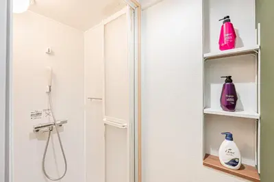 a bathroom with a shower and two bottles of soap at \u65e5\u66ae\u91ccMori House B in Tokyo