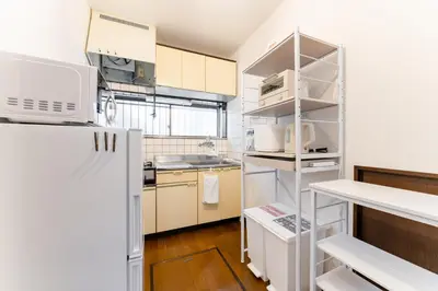 a small kitchen with a white refrigerator in a room at Sushi Art Hotel at Kamiisshiki\u5bff\u53f8\u30a2\u30fc\u30c8\u30db\u30c6\u30ebat\u4e0a\u4e00\u8272 in Tokyo