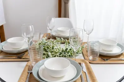 a dining room table with plates and glasses on it at Sushi Art Hotel at Kamiisshiki\u5bff\u53f8\u30a2\u30fc\u30c8\u30db\u30c6\u30ebat\u4e0a\u4e00\u8272 in Tokyo