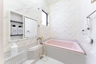 a bathroom with a pink tub and a sink at Sushi Art Hotel at Kamiisshiki\u5bff\u53f8\u30a2\u30fc\u30c8\u30db\u30c6\u30ebat\u4e0a\u4e00\u8272 in Tokyo