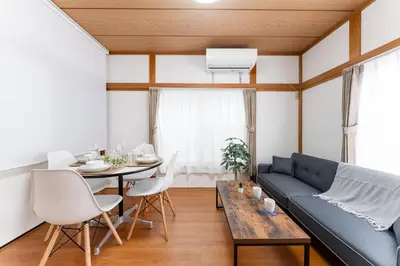 a living room with a blue couch and a table at Sushi Art Hotel at Kamiisshiki\u5bff\u53f8\u30a2\u30fc\u30c8\u30db\u30c6\u30ebat\u4e0a\u4e00\u8272 in Tokyo