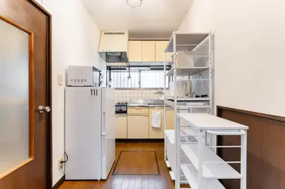 a kitchen with a white refrigerator and a ladder at Sushi Art Hotel at Kamiisshiki\u5bff\u53f8\u30a2\u30fc\u30c8\u30db\u30c6\u30ebat\u4e0a\u4e00\u8272 in Tokyo