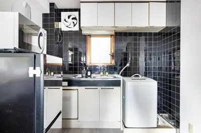 a kitchen with white cabinets and a sink at \u6771\u4eac\u5927\u7530\u533a\u5e73\u548c\u5cf6\u30a2\u30d1\u30fc\u30c8\u30e1\u30f3\u30c8 in Tokyo