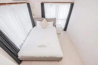 a white bed in a room with windows at 67Apt Shinkoiwa in Tokyo