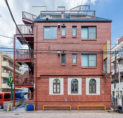 a red brick building with stairs on top of it at 67Apt Shinkoiwa in Tokyo