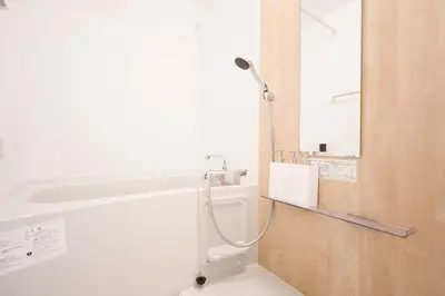 a bathroom with a shower and a sink and a mirror at Tell House in Tokyo