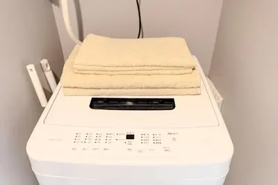 a stack of towels on top of a washing machine at Tell House in Tokyo