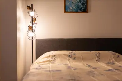 a bedroom with a bed with a lamp next to it at Tell House in Tokyo