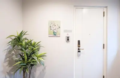 a white door with a plant next to it at Tell House in Tokyo
