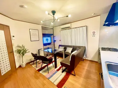 a living room with a table and a couch at \u6e0b\u8c37\u533a\u306e\u4e00\u8ed2\u5bb6 80\u5e73\u7c73 3\u5bdd\u5ba46\u30d9\u30c3\u30c9 \u5e61\u30f6\u8c37\u99c5\u5f92\u6b695\u5206 \u65b0\u5bbf\u307e\u3067\u96fb\u8eca4\u5206 in Tokyo