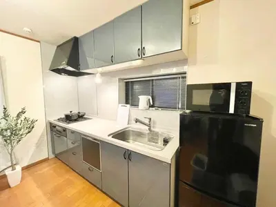 a kitchen with a sink and a black refrigerator at \u6e0b\u8c37\u533a\u306e\u4e00\u8ed2\u5bb6 80\u5e73\u7c73 3\u5bdd\u5ba46\u30d9\u30c3\u30c9 \u5e61\u30f6\u8c37\u99c5\u5f92\u6b695\u5206 \u65b0\u5bbf\u307e\u3067\u96fb\u8eca4\u5206 in Tokyo